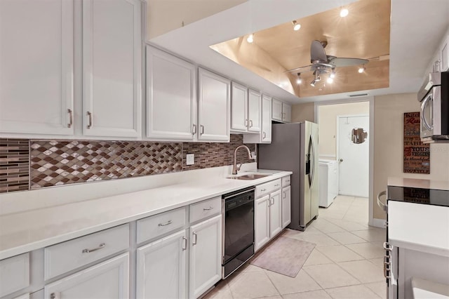 kitchen with stainless steel appliances, a sink, a tray ceiling, tasteful backsplash, and ceiling fan