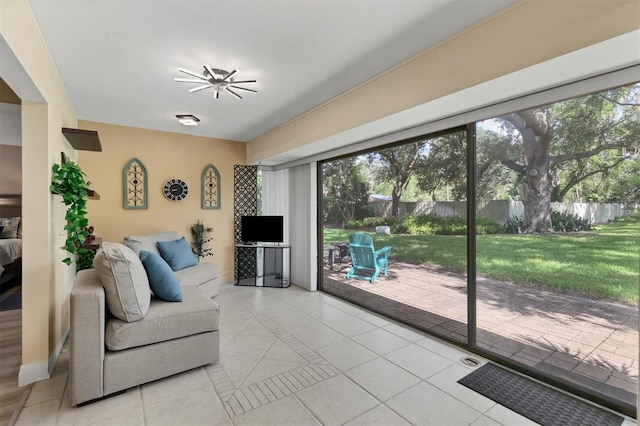 living room with light tile patterned floors, plenty of natural light, and ceiling fan