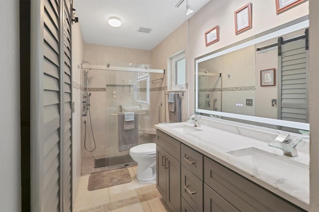 full bathroom featuring toilet, a stall shower, tile patterned flooring, and double vanity