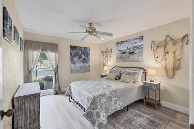 bedroom with a textured ceiling, hardwood / wood-style flooring, and ceiling fan