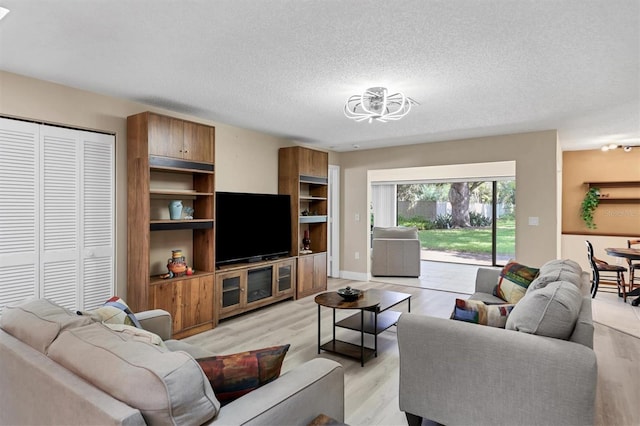 living room with a textured ceiling and light wood-type flooring