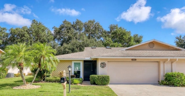 ranch-style house featuring a front yard, an attached garage, roof with shingles, and concrete driveway