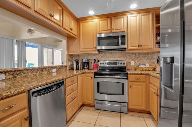 kitchen featuring light tile patterned floors, light stone counters, backsplash, and stainless steel appliances