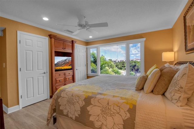 bedroom featuring ceiling fan, ornamental molding, and light wood-type flooring