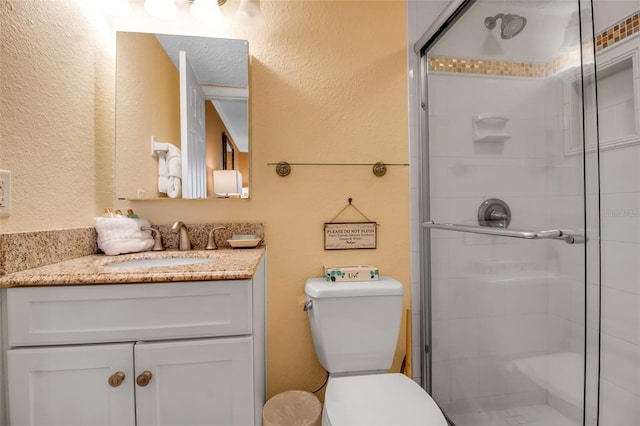 bathroom featuring walk in shower, toilet, and vanity