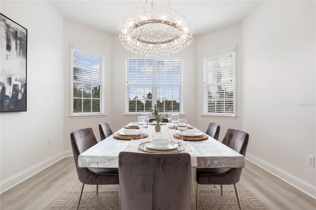 dining area featuring wood-type flooring and an inviting chandelier