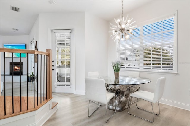 dining area featuring a notable chandelier and light wood-type flooring