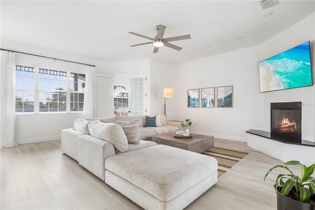 living room with ceiling fan and light wood-type flooring