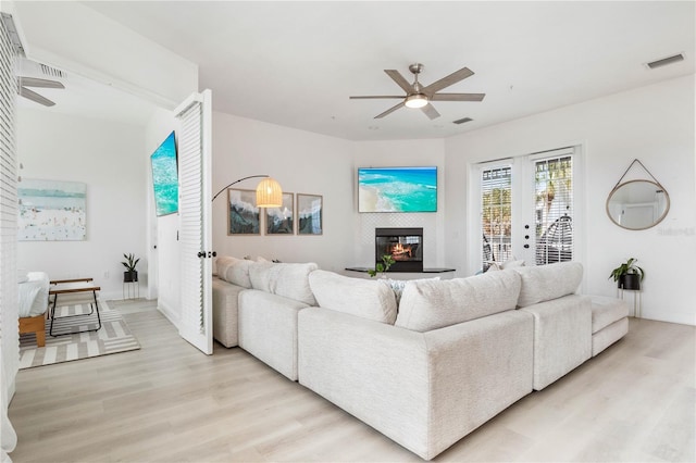 living room with light hardwood / wood-style flooring and ceiling fan