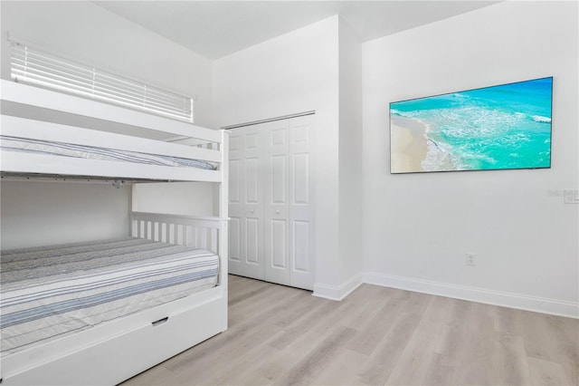 unfurnished bedroom with light wood-type flooring and a closet