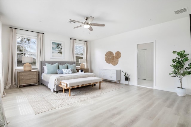 bedroom with multiple windows, ceiling fan, and light hardwood / wood-style floors