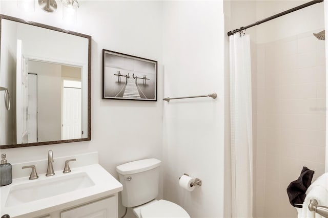 bathroom featuring vanity, toilet, and walk in shower