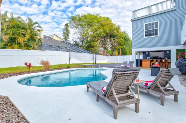 view of swimming pool with an outdoor bar, a patio area, and an outdoor kitchen