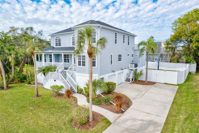 view of front of property with cooling unit, a porch, a garage, and a front lawn