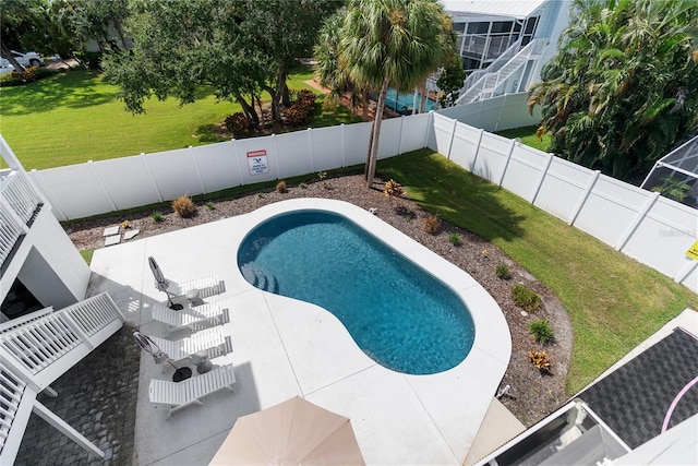 view of pool with a lawn and a patio