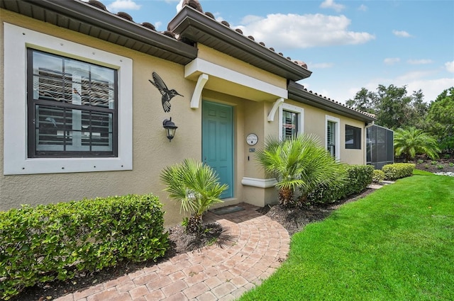 view of exterior entry featuring a yard