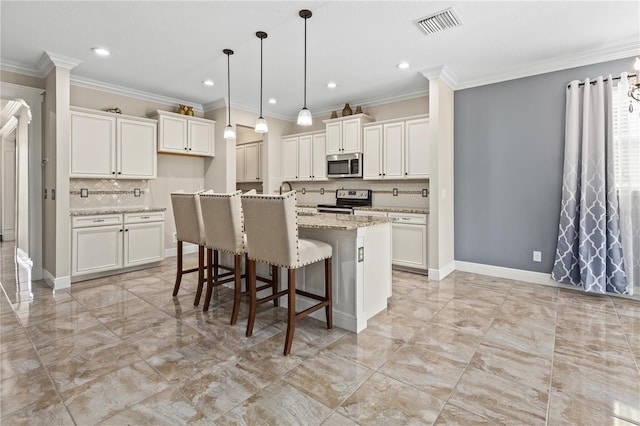 kitchen with white cabinets, a kitchen island with sink, appliances with stainless steel finishes, light stone countertops, and crown molding