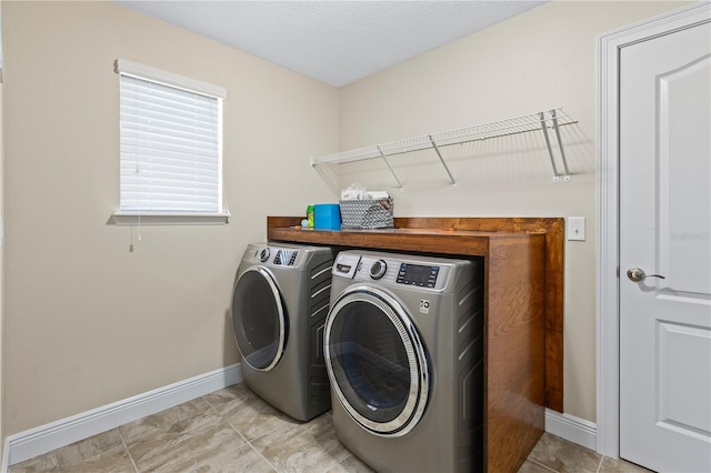 laundry area featuring a textured ceiling and separate washer and dryer