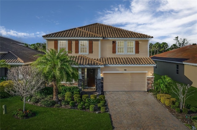 mediterranean / spanish home with a front lawn and a garage