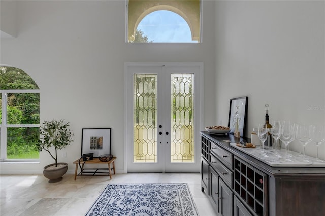 entryway featuring a wealth of natural light, a high ceiling, and french doors