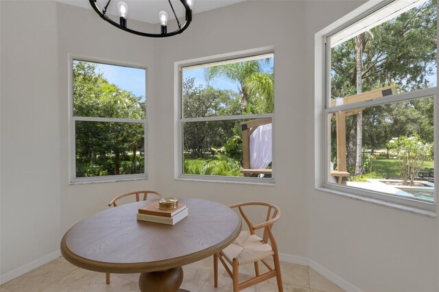 dining space with light tile patterned floors and an inviting chandelier