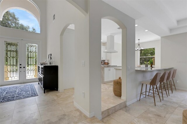 interior space with french doors, a healthy amount of sunlight, and a chandelier