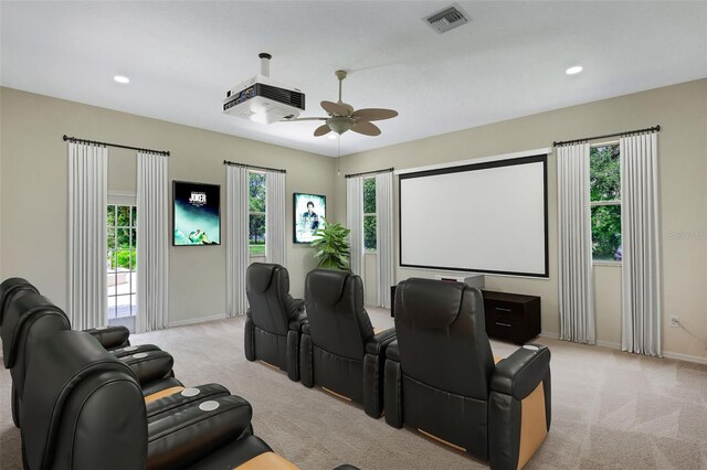 carpeted cinema room with ceiling fan and plenty of natural light