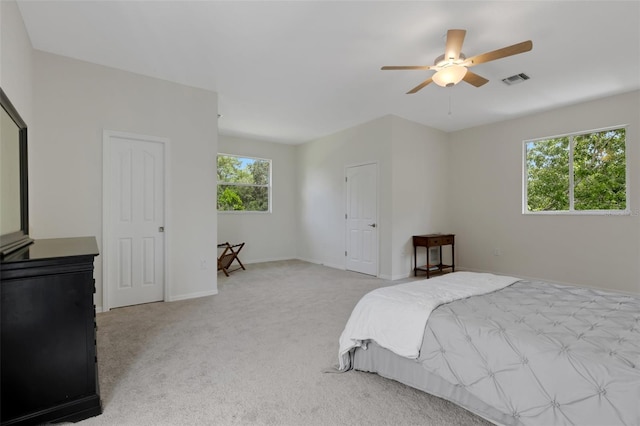 bedroom with multiple windows, light colored carpet, and ceiling fan