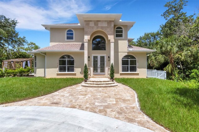 mediterranean / spanish home featuring a front yard and french doors