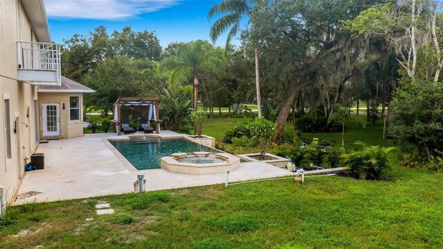 view of pool featuring a patio area, a yard, and an in ground hot tub