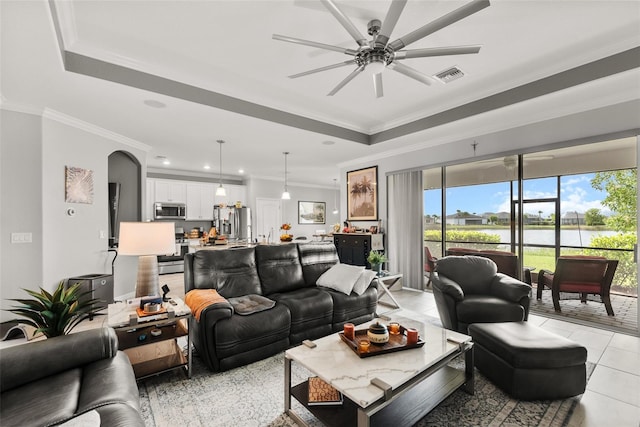 living room featuring crown molding, a raised ceiling, light tile patterned floors, and ceiling fan