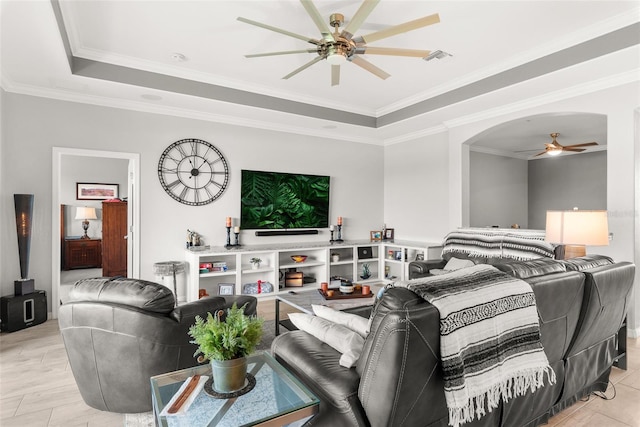 living room featuring crown molding, a tray ceiling, and ceiling fan