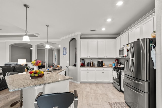 kitchen featuring stainless steel appliances, white cabinetry, and light hardwood / wood-style floors