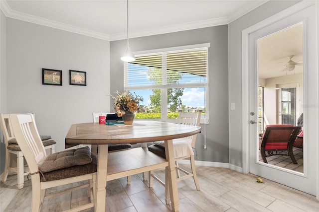 dining area featuring light wood-type flooring, ornamental molding, and a healthy amount of sunlight