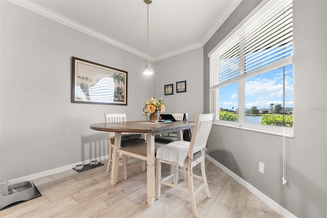 dining area featuring a water view and ornamental molding