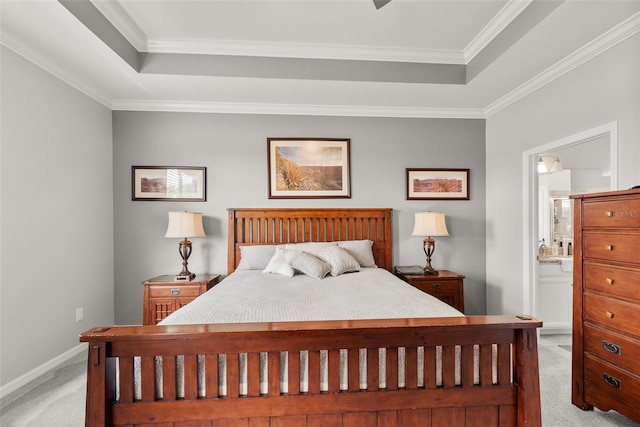 carpeted bedroom featuring crown molding, ensuite bath, and a raised ceiling