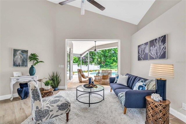 living room with lofted ceiling, hardwood / wood-style flooring, and ceiling fan