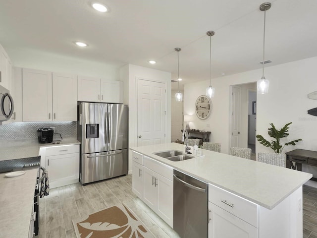 kitchen featuring a kitchen island with sink, light hardwood / wood-style flooring, stainless steel appliances, sink, and white cabinets