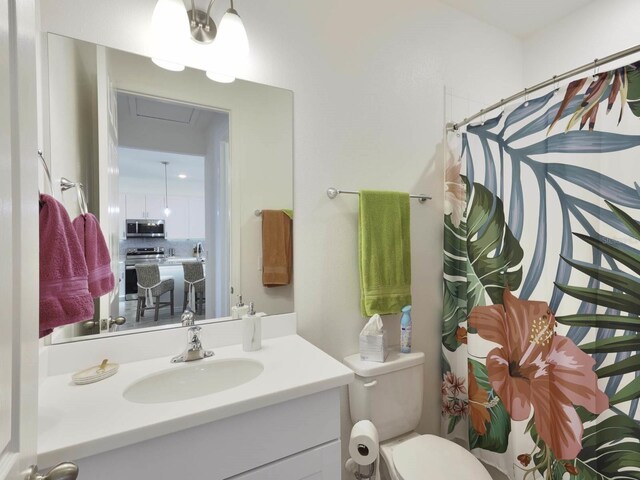 bathroom featuring vanity, toilet, and a shower with curtain