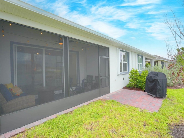 rear view of house with a lawn and a sunroom