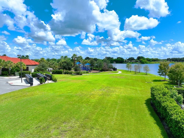 view of home's community with a water view and a yard