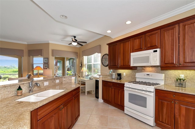 kitchen featuring light stone counters, ceiling fan, sink, and white appliances