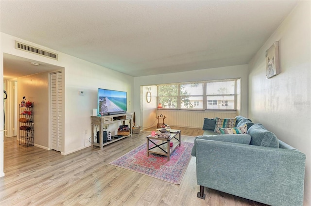 living room with hardwood / wood-style floors and a textured ceiling