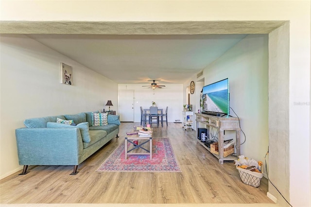 living room featuring wood-type flooring and ceiling fan