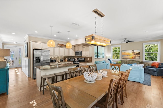 dining room featuring light hardwood / wood-style flooring, ceiling fan, and crown molding