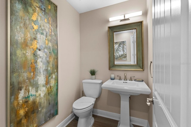 bathroom featuring hardwood / wood-style flooring and toilet