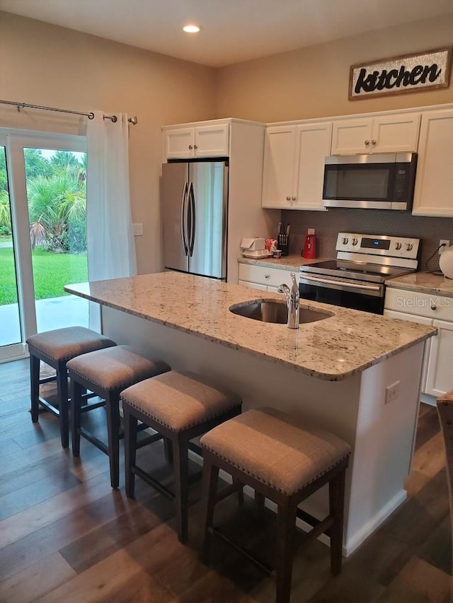 kitchen with a center island with sink, sink, appliances with stainless steel finishes, and white cabinetry