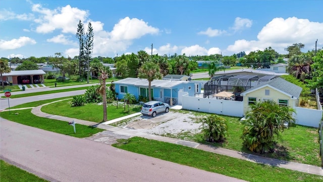 view of front of home featuring a residential view, a lanai, a front yard, and fence