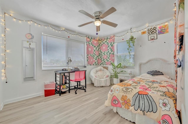 bedroom with ceiling fan, light wood-type flooring, and multiple windows