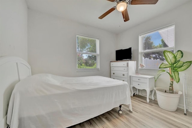 bedroom featuring multiple windows, light wood-style floors, and ceiling fan